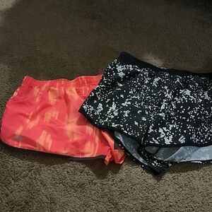 Two pairs of under armor shorts both with the inner lining